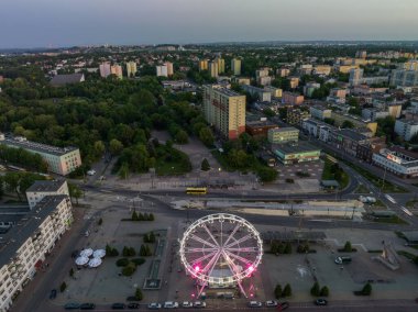 Geceleri kuş bakışı bir drondan renkli dönme dolap. Şehir merkezinde büyük renkli dönme dolap. Dabrowa Gornicza Polonya şehir merkezinde dönen Renkli Dönme Dönme dolabının hava aracı görüntüsü