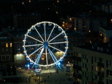 Geceleri kuş bakışı bir drondan renkli dönme dolap. Şehir merkezinde büyük renkli dönme dolap. Dabrowa Gornicza Polonya şehir merkezinde dönen Renkli Dönme Dönme dolabının hava aracı görüntüsü