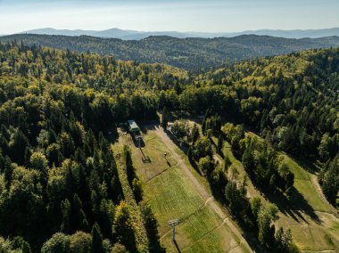 Beskid dağ sıraları. Beskid Maly Poland.Beskid Maly 'deki Rzyki köyünün insansız hava aracı görüntüsü. Potrojna tepesi ve kertenkele gronu. Polonya' nın Rzyki kentindeki Czarny gron kayak merkezi..