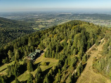 Little Beskids mountain range.Aerial drone view of Rzyki Village in Beskid Maly Poland.Beskid Maly aerial panorama of potrojna hill and czarny gron.Czarny gron ski resort in Rzyki, Andrychow, Poland. clipart