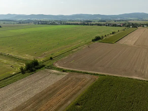 stock image Green field in the countryside in summer full of straw bales in the Opole province in Poland. Aerial View of Summer Field Landscape With With Dry Hay Bales During Harvest. 