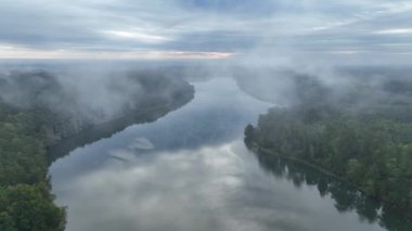 Yeşil ormanla çevrili bir gölün hava aracı görüntüsü. Siste ve bulutlarda büyük bir göl. Masurian Gölü bölgesinde bir göl. Polonya 'daki Kulka Reserve' de Lesk Gölü. Kulka rezervi, Masuria, Polonya.