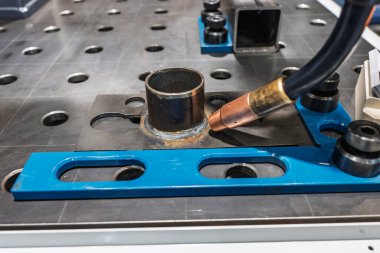 Robot çeliği kaynak yapar. Kaynak kafa. Kaynak robotu. CNC kaynaklama. Kaynak işleminin robotlaştırılması ve otomasyonu. Robot kaynak çeliği. Endüstriyel kaynak robotu ve metal parçalarıyla çalışıyor.