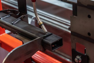 Robot çeliği kaynak yapar. Kaynak kafa. Kaynak robotu. CNC kaynaklama. Kaynak işleminin robotlaştırılması ve otomasyonu. Robot kaynak çeliği. Endüstriyel kaynak robotu ve metal parçalarıyla çalışıyor.