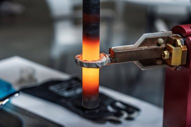 İndüksiyon sertleştirici yüzey sertleşmesi. Metal kısmı indüksiyon ısıtılıp söndürülüyor. Söndürülmüş metal. İndüksiyon ısıtma işlemi. Elektromanyetik indüksiyon. Çeliğin yüzeyi sertleşiyor..