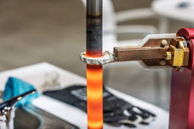 İndüksiyon sertleştirici yüzey sertleşmesi. Metal kısmı indüksiyon ısıtılıp söndürülüyor. Söndürülmüş metal. İndüksiyon ısıtma işlemi. Elektromanyetik indüksiyon. Çeliğin yüzeyi sertleşiyor..