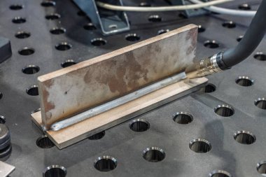 Robot çeliği kaynak yapar. Kaynak kafa. Kaynak robotu. CNC kaynaklama. Kaynak işleminin robotlaştırılması ve otomasyonu. Robot kaynak çeliği. Endüstriyel kaynak robotu ve metal parçalarıyla çalışıyor.