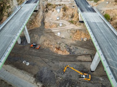 Viyadük ve tünelleri olan bir otoyol inşaatı Baskid dağları. Sonbaharda dağlarda tamamlanmamış otoyol inşaatının insansız hava aracı görüntüsü. Beskid dağlarında otoyol inşaatı.