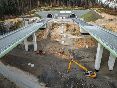 Construction of a highway with viaducts and tunnels baskid mountains.Aerial drone view of unfinished highway construction site in mountains in autumn. Construction of expressway in beskid mountains. clipart