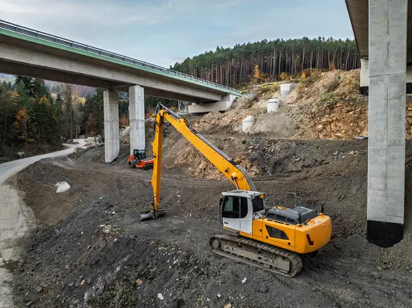Viyadük ve tünelleri olan bir otoyol inşaatı Baskid dağları. Sonbaharda dağlarda tamamlanmamış otoyol inşaatının insansız hava aracı görüntüsü. Beskid dağlarında otoyol inşaatı.