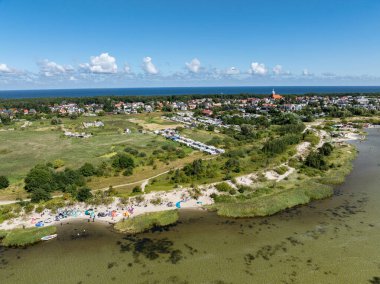 İnsanlar denizde uçurtma sörfü ya da uçurtma sörfü yapıyor. Yaz sporu uçurtma uçurmayı öğreniyor. Körfezde uçurtma sörfü dersleri. Kite sörfü. Hel Yarımadası, Puck Körfezi, Jastarnia, Polonya.