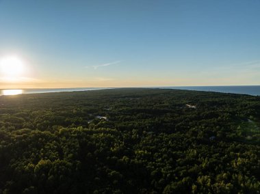 Polonya 'da Hel Plajı. Denizde ve koyda gün batımı, Poland. Hel City. Polonya, Baltık Denizi ve Puck Körfezi 'ndeki Hel Yarımadası' nın havadan görünüşü. Yukarıdan insansız hava aracı tarafından havadan çekilmiş bir fotoğraf. Poland hel yarımadasının sonu. 