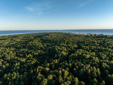 Polonya 'da Hel Plajı. Denizde ve koyda gün batımı, Poland. Hel City. Polonya, Baltık Denizi ve Puck Körfezi 'ndeki Hel Yarımadası' nın havadan görünüşü. Yukarıdan insansız hava aracı tarafından havadan çekilmiş bir fotoğraf. Poland hel yarımadasının sonu. 