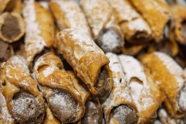 Cannoli, Sicilian pastry consisting of a tube shaped shell of fried pastry dough, filled with a sweet, creamy filling containing ricotta cheese. Italian cannolo and Sicilian cannolu clipart