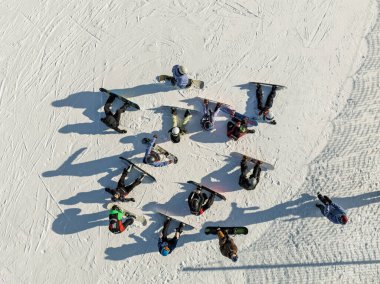 Bir grup snowboardcunun kış inişi için hava aracı görüntüsü. Dağda bir grup snowboardcu. Dolomitler içinde güneşli bir kış günü.