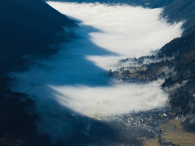 Dolomitler, Pinzolo köyü ve İtalya 'da bir kayak merkezindeki güneşli kışın insansız hava aracı görüntüsü. Dolomitler Brenta, Dolomitler 'in sisle kaplı kasabası, insansız hava aracının görüntüsü....
