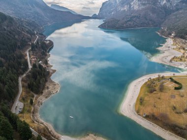Molveno Gölü 'nün hava aracı manzarası, İtalya' daki güzel göl. Güneşli kışta drone 'dan gelen dolomitlerle dolu bir göl. Brenta Dolomites 'teki Molveno Gölü. Molveno Gölü boyunca uzanan dağlar, Trentino, İtalya.