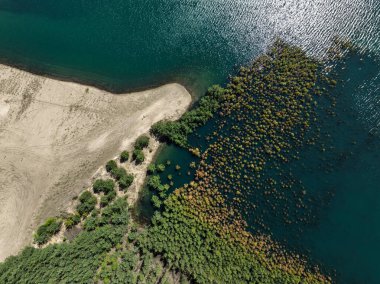 Polonya 'nın Olkusz kentindeki Pomorzany madeninde meydana gelen hasar sonucu su altında kalan bir göl bölgesi. Sel basmış kum çukurunun hava aracı görüntüsü. Orman bir göle battı. Temiz suyu olan batık bir kum havuzu
