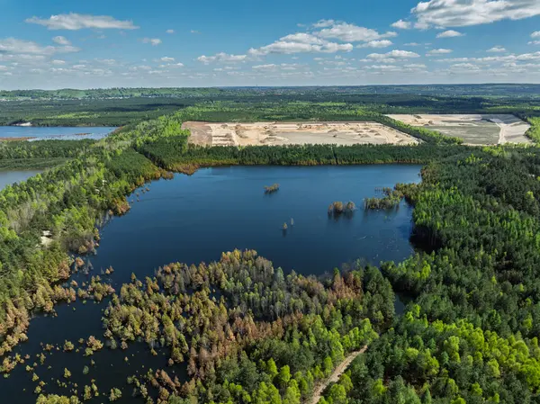 Polonya 'nın Olkusz kentindeki Pomorzany madeninde meydana gelen hasar sonucu su altında kalan bir göl bölgesi. Sel basmış kum çukurunun hava aracı görüntüsü. Orman bir göle battı. Temiz suyu olan batık bir kum havuzu