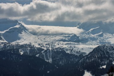 Dolomitlerde, Alplerde güneşli kış manzarası. Madonna di Campiglio köyü, İtalya 'da sis ve bulutlarla kaplı bir kayak merkezi. Madonna di Campiglio ursus kar parkı Val Rendena dolomites trentino Italy.