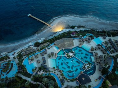 Türkiye 'nin Alanya kentindeki Türkler üzerinde gece karanlığına muhteşem hava günbatımı. Alanya kıyı şeridi, tatil beldeleri, marina, oteller ve Akdeniz insansız hava aracı manzaralı şehir ışıkları. Akdeniz kıyı şeridi