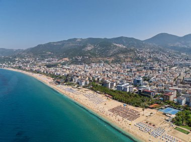 Alanya, Türkiye 'deki Kleopatra Sahili' nin insansız hava aracı görüntüsü. Alanya turkuvaz denizi, kumlu plaj, uçurumlar, mağaralı tepeler ve yukarıdan güneşli yaz günü kıyı şeridi. Yaz Akdeniz