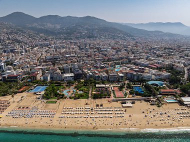 Alanya, Türkiye 'deki Kleopatra Sahili' nin insansız hava aracı görüntüsü. Alanya turkuvaz denizi, kumlu plaj, uçurumlar, mağaralı tepeler ve yukarıdan güneşli yaz günü kıyı şeridi. Yaz Akdeniz