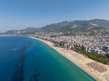 Alanya, Türkiye 'deki Kleopatra Sahili' nin insansız hava aracı görüntüsü. Alanya turkuvaz denizi, kumlu plaj, uçurumlar, mağaralı tepeler ve yukarıdan güneşli yaz günü kıyı şeridi. Yaz Akdeniz