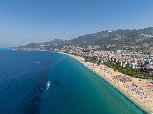Alanya, Türkiye 'deki Kleopatra Sahili' nin insansız hava aracı görüntüsü. Alanya turkuvaz denizi, kumlu plaj, uçurumlar, mağaralı tepeler ve yukarıdan güneşli yaz günü kıyı şeridi. Yaz Akdeniz