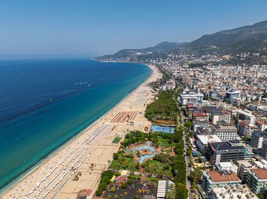 Alanya, Türkiye 'deki Kleopatra Sahili' nin insansız hava aracı görüntüsü. Alanya turkuvaz denizi, kumlu plaj, uçurumlar, mağaralı tepeler ve yukarıdan güneşli yaz günü kıyı şeridi. Yaz Akdeniz