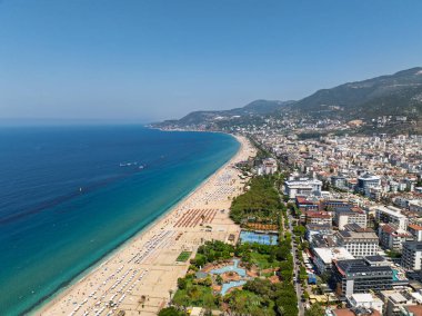 Alanya, Türkiye 'deki Kleopatra Sahili' nin insansız hava aracı görüntüsü. Alanya turkuvaz denizi, kumlu plaj, uçurumlar, mağaralı tepeler ve yukarıdan güneşli yaz günü kıyı şeridi. Yaz Akdeniz