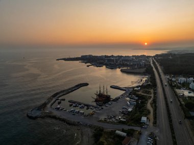 Türkiye 'nin Alanya kentindeki Türkler üzerinde gece karanlığına muhteşem hava günbatımı. Alanya kıyı şeridi, tatil beldeleri, marina, oteller ve Akdeniz insansız hava aracı manzaralı şehir ışıkları. Akdeniz kıyı şeridi