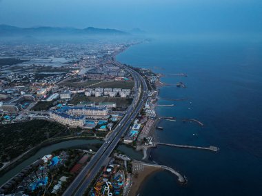 Türkiye 'nin Alanya kentindeki Türkler üzerinde gece karanlığına muhteşem hava günbatımı. Alanya kıyı şeridi, tatil beldeleri, marina, oteller ve Akdeniz insansız hava aracı manzaralı şehir ışıkları. Akdeniz kıyı şeridi