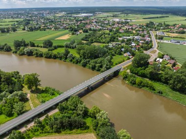 Lezajsk, Polonya 'daki San River' ın deniz üzerinden geçen bir köprüsünün hava aracı görüntüsü. Yeşillik, akan nehir ve kasaba çevresiyle manzaralı yaz manzarası. 