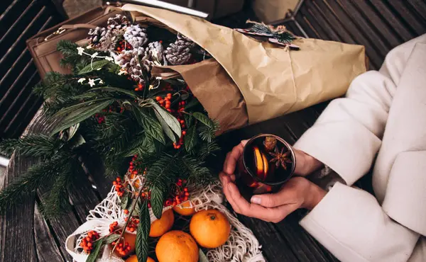 Bir kadeh kırmızı şarap bayanların elinde. Sıcak şarap portakal, tarçın ve anason ile süslenir. Avrupa 'da Noel pazarı. Yeni yıl. Tatillerde. Bir buket köknar dalı ve kırmızı böğürtlen. Kış Fuarı. 
