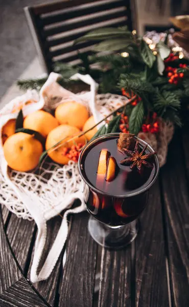Bir bardak sıcak kırmızı şarap, portakal, tarçın ve yıldız anason ile süslenmiş. Avrupa 'da Noel pazarı. Yeni yıl. Sıcak kış içeceği. Tatil günü. Bir buket köknar dalı ve kırmızı böğürtlen. Kış Fuarı.