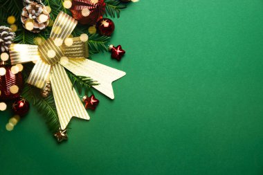 Altın fiyonklu yeşil Noel arkaplanı, Noel ağacı dalları ve Noel kırmızısı ve altın katmanlı. Tebrik kartı. Yeni yıl ve Noel. Boşluğu kopyala.