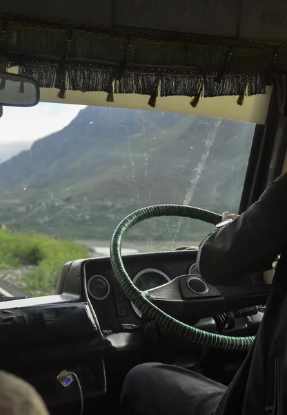 Rear view of a unrecognized man driving passenger van (tempo traveller) in Manali-Leh highway during summer season