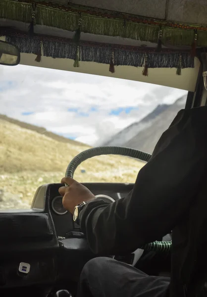 Unrecognized person driving passenger van (tempo traveller) in Manali-Leh highway with beautiful mountains view during summer season.