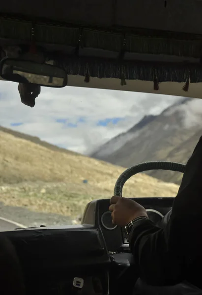 Unrecognized person driving passenger van (tempo traveller) in Manali-Leh highway with beautiful mountains view during summer season.