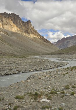 Beautiful Landscape view of flowing a river in between Dry mountains of Leh, Ladakh with cloudy sky in summer.