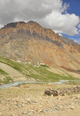Darcha-Padum yolu, Ladakh, Hindistanda nehir akan güzel kayalık bir dağın yanındaki köy manzarası.
