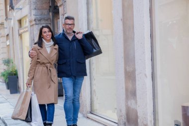 Mutlu çift tatillerde Verona 'da alışverişi ve manzarayı seviyor. Elinde çantalarla koşuşturan sokaklarda yürüyorsun. Sevgi ve beraberlik yaymak. Şenlikli kış ortamını keşfediyorum.