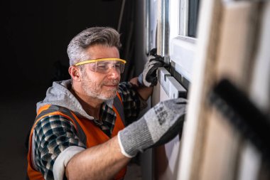 Yetenekli bir işçinin yeni yapılmış bir inşaat alanının yatay hizalanmasını sağlamak için ruh seviyesini kullanarak yakın plan çekimleri.