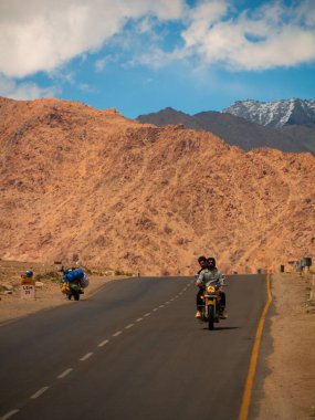 Ladakh, Hindistan - 26 Haziran 2022: Nubra Vadisi, Leh Ladakh, Jammu ve Kashmir, Hindistan 'da Diskit ve Khardung La Pass arasında güzel manzaranın tadını çıkaran bisikletçiler.