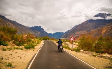 Ladakh, Hindistan - 26 Haziran 2022: Nubra Vadisi, Leh Ladakh, Jammu ve Kashmir, Hindistan 'da Diskit ve Khardung La Pass arasında güzel manzaranın tadını çıkaran bisikletçiler.