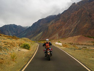 Ladakh, Hindistan - 26 Haziran 2022: Nubra Vadisi, Leh Ladakh, Jammu ve Kashmir, Hindistan 'da Diskit ve Khardung La Pass arasında güzel manzaranın tadını çıkaran bisikletçiler.