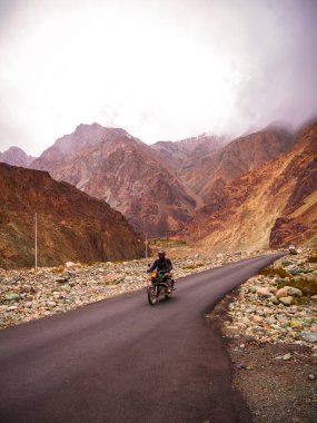 Ladakh, Hindistan - 26 Haziran 2022: Nubra Vadisi, Leh Ladakh, Jammu ve Kashmir, Hindistan 'da Diskit ve Khardung La Pass arasında güzel manzaranın tadını çıkaran bisikletçiler.