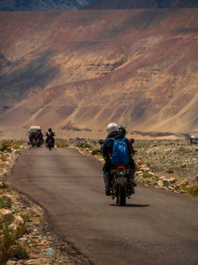 Ladakh, Hindistan - 26 Haziran 2022: Nubra Vadisi, Leh Ladakh, Jammu ve Kashmir, Hindistan 'da Diskit ve Khardung La Pass arasında güzel manzaranın tadını çıkaran bisikletçiler.