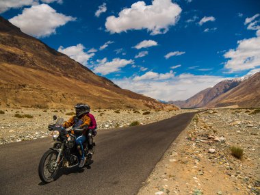 Ladakh, Hindistan - 26 Haziran 2022: Nubra Vadisi, Leh Ladakh, Jammu ve Kashmir, Hindistan 'da Diskit ve Khardung La Pass arasında güzel manzaranın tadını çıkaran bisikletçiler.
